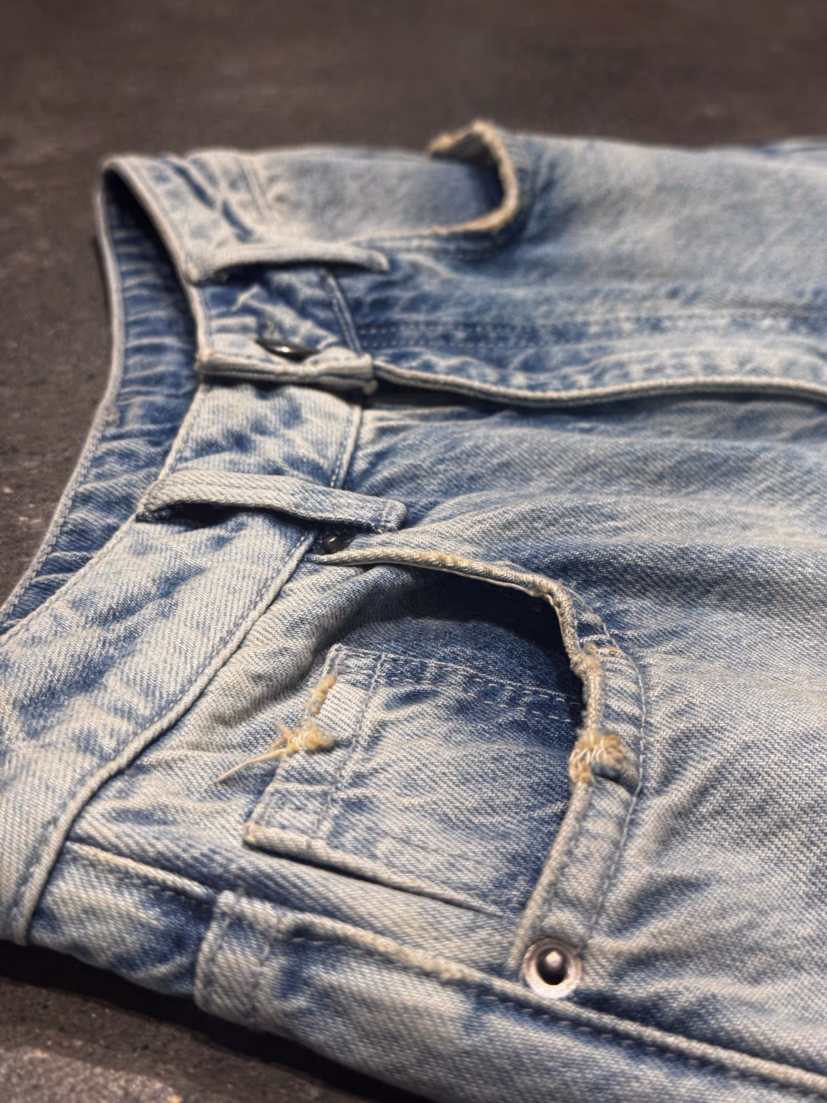 Light-wash denim jeans pocket and waistband detail
