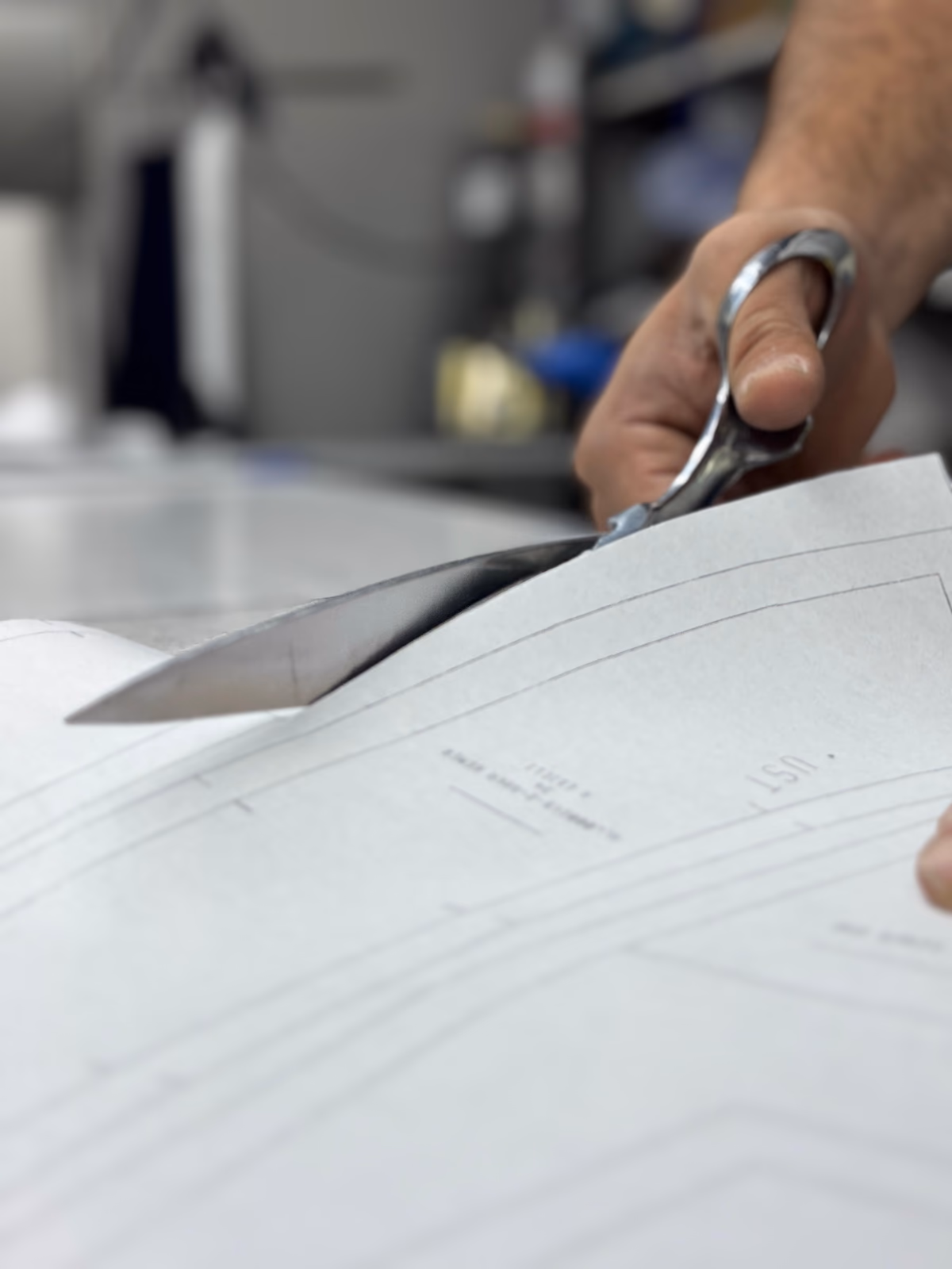 Cutting a garment paper pattern with professional shears