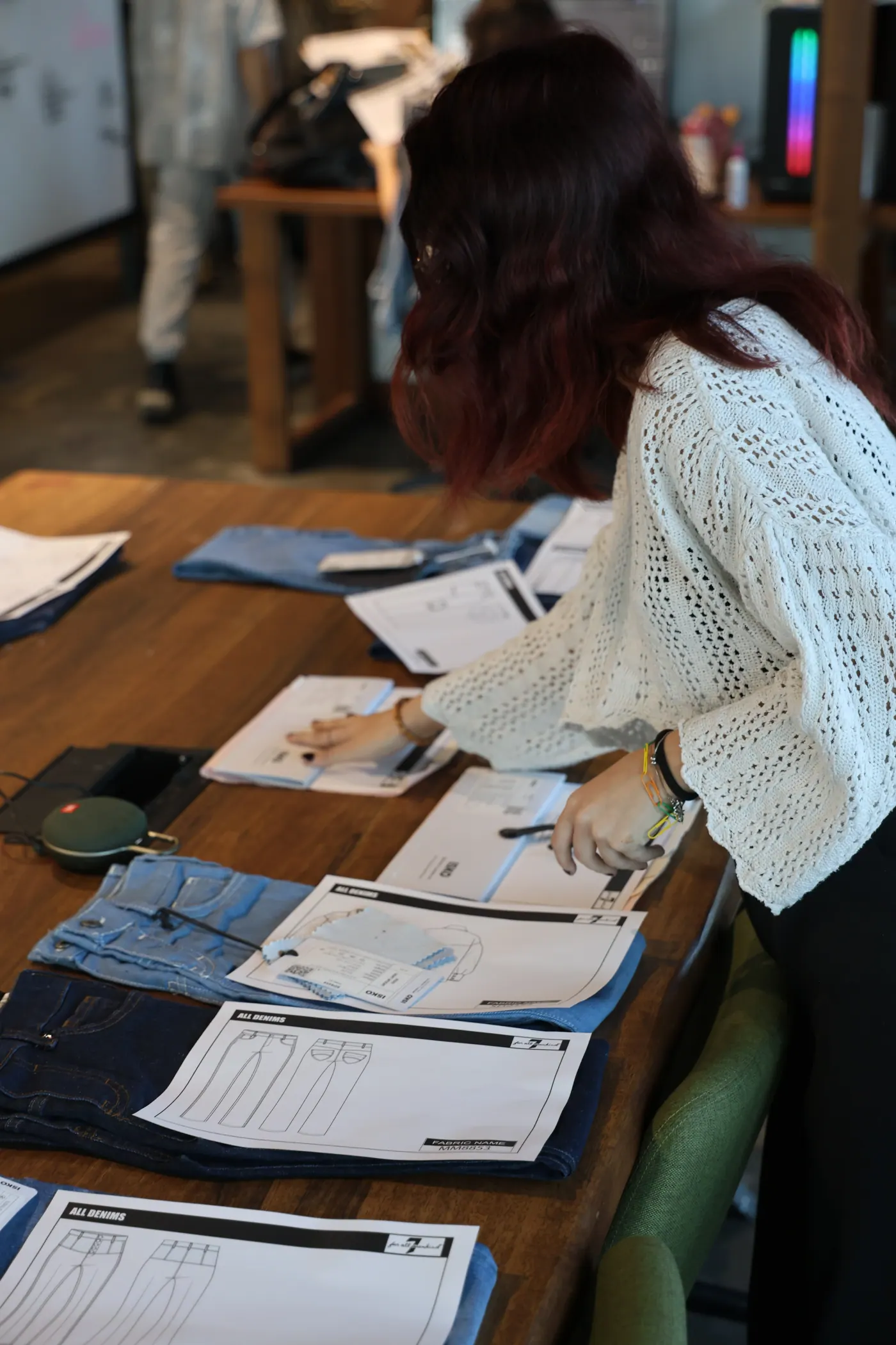 ALLDENIMS design studio — reviewing denim samples at a work table