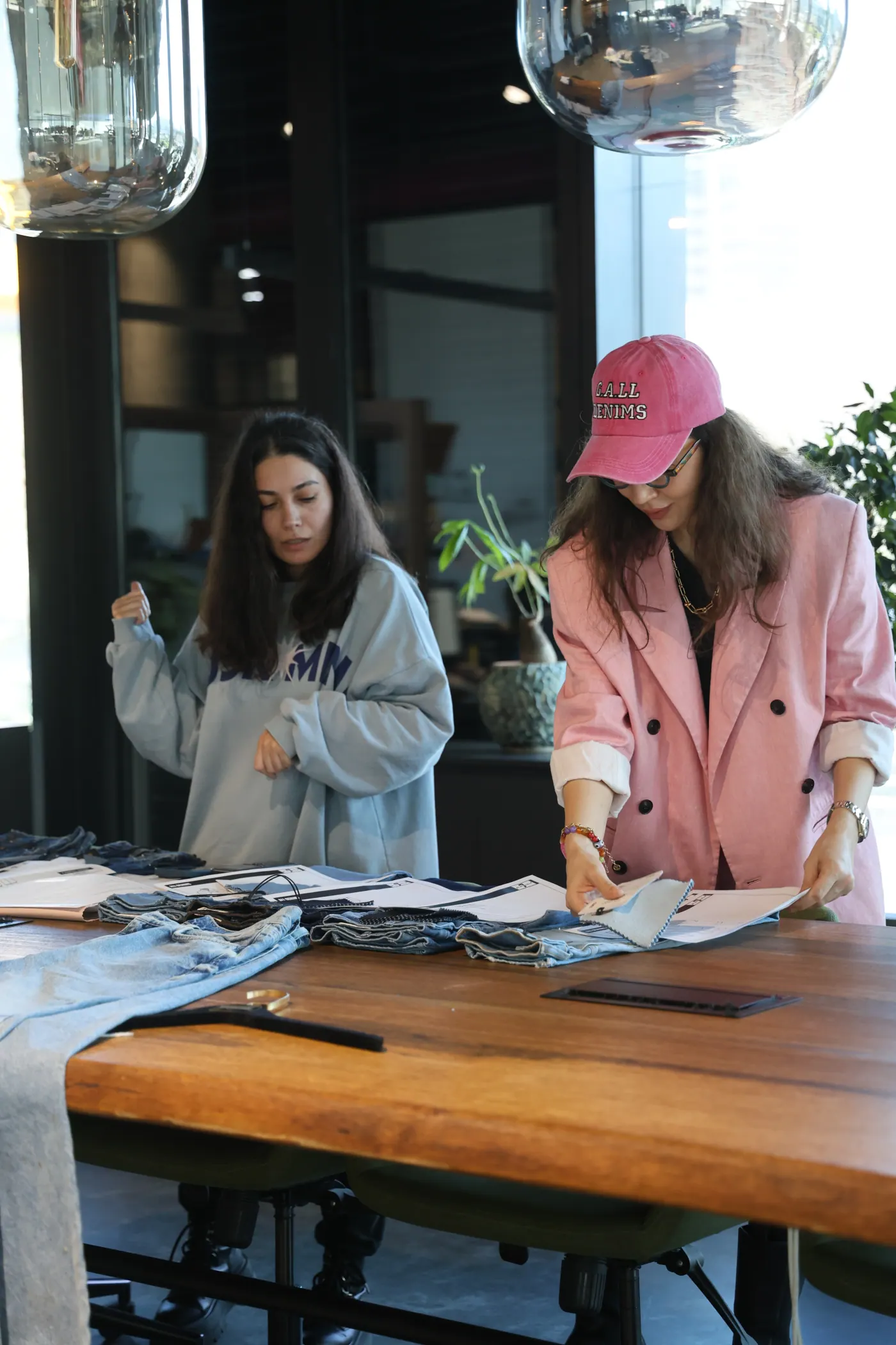 ALLDENIMS team reviewing denim garments in the studio