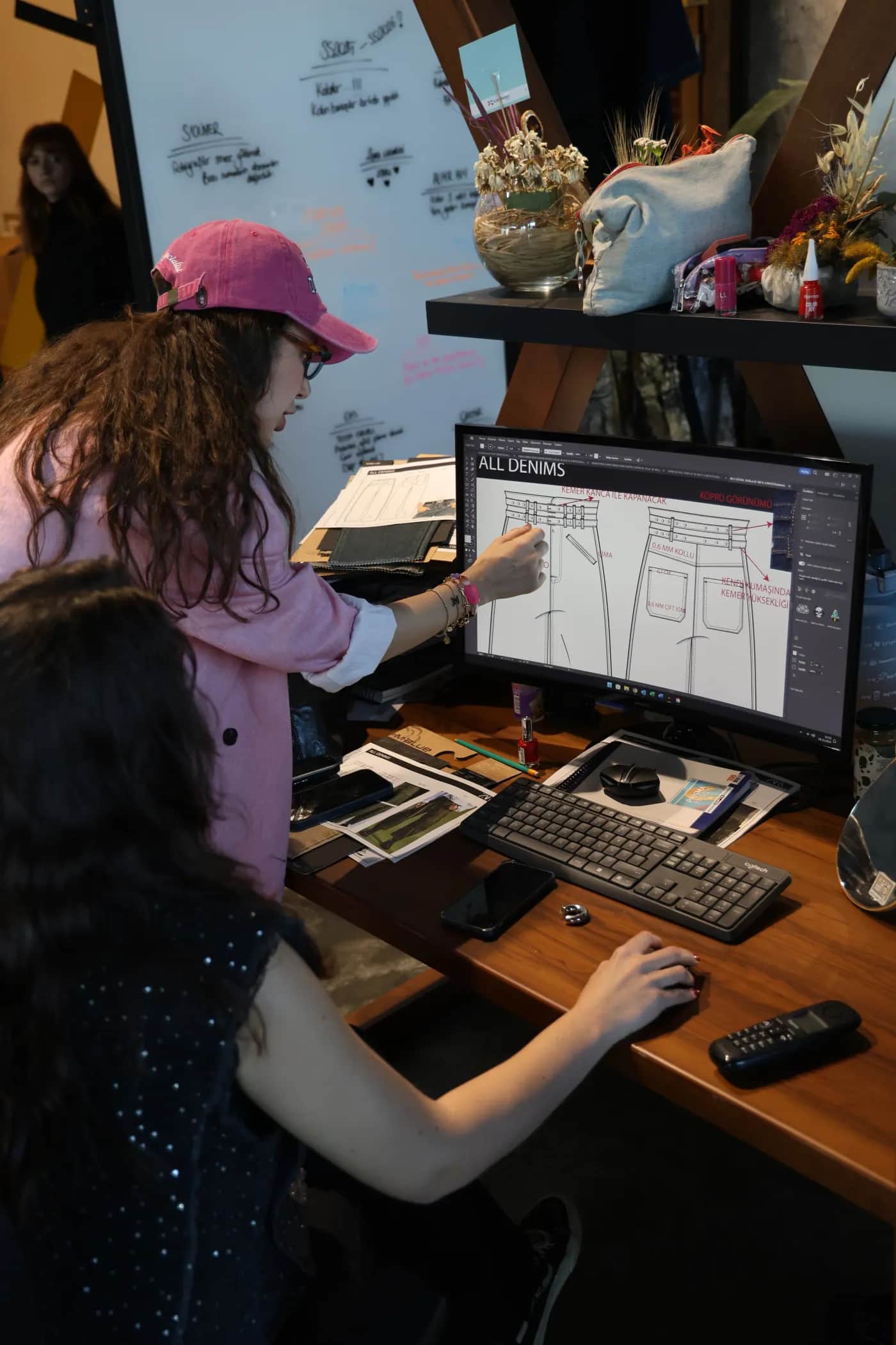 ALLDENIMS design team collaborating at a computer workstation
